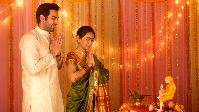 印度夫妇穿着民族服装在家进行礼拜——向赛巴巴祈祷视频素材