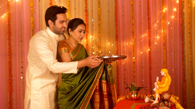 印度夫妇在家里举行宗教仪式-普贾，赛巴巴视频素材
