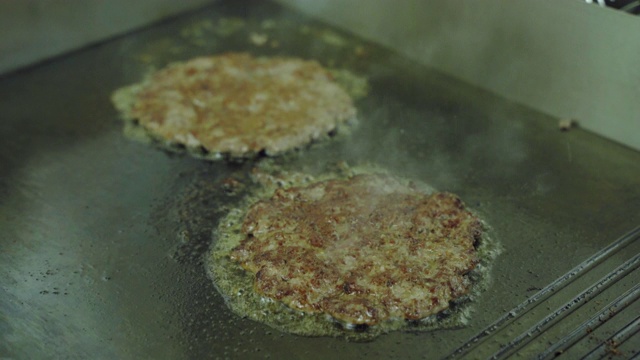 烹饪的汉堡。厨房里用专业平底锅煎的多汁肉排。视频素材