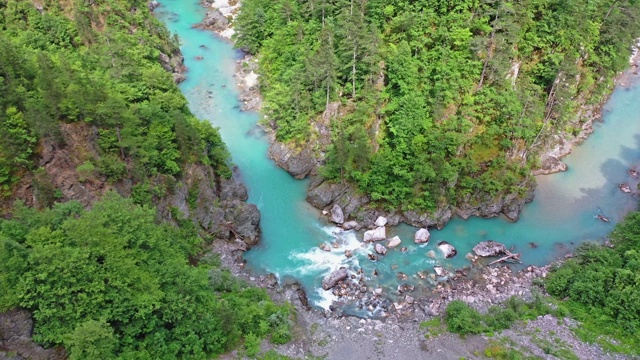 一架四轴飞行器飞越一座山的河流峡谷视频素材