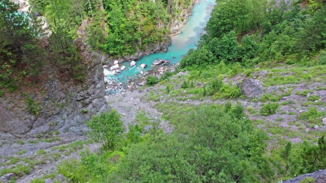 一架四轴飞行器飞越一座山的河流峡谷视频素材