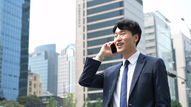 正式的韩国商人通过电话与商业伙伴进行沟通视频下载