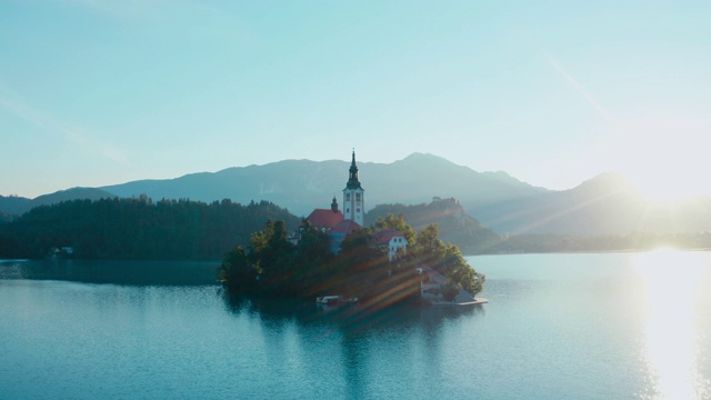 一张湖中央有教堂的小岛的美丽照片，阳光照进了相机。视频下载