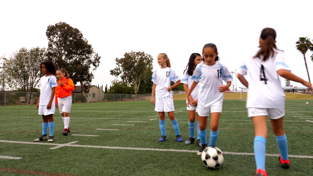 年轻的女足球运动员在比赛前在场上进行热身训练视频素材