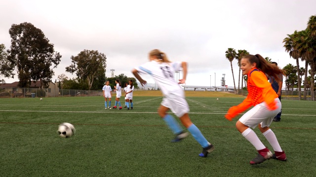 MS年轻女子足球队在赛前与教练练习运球视频素材