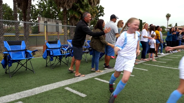 足球比赛结束后，年轻的女球员在场边与父母击掌视频素材