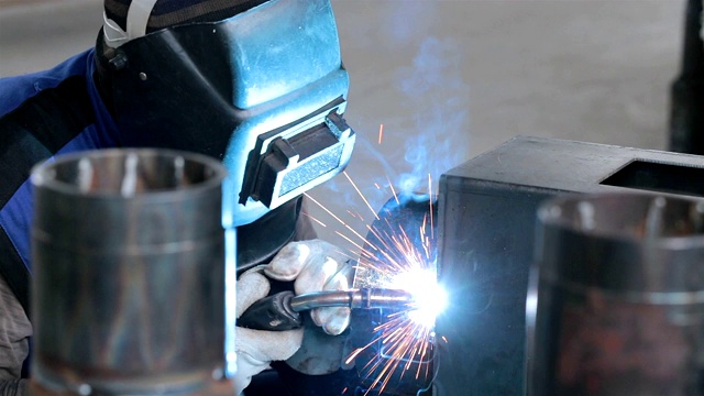 焊工在生产线上焊接金属零件。视频下载