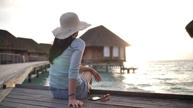 女人坐在度假胜地欣赏日落视频下载