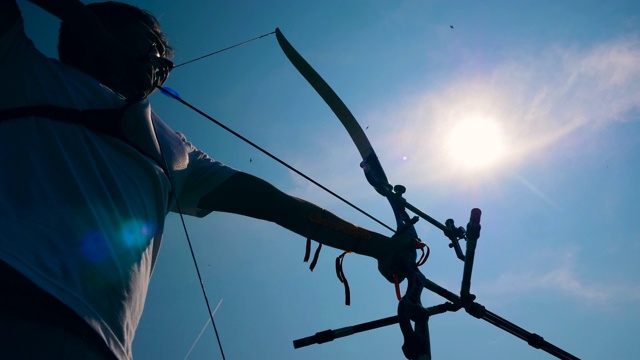 弓箭手在阳光下拉弓。用弓和箭射击视频素材