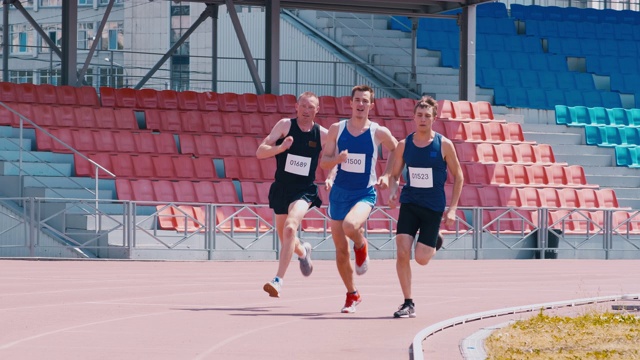 三位男运动员正在跑道上赛跑视频下载