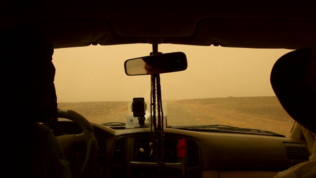 一辆吉普车和乘客在炎热的天气里行驶在摩洛哥撒哈拉沙漠的道路上。视频下载