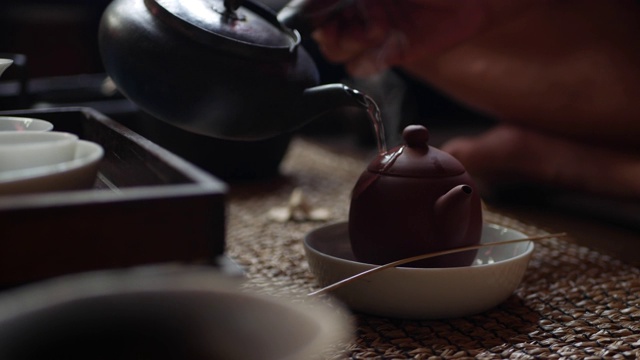 传统的中国功夫或功夫茶道。开水倒进壶里。茶师将水倒进茶壶中，加入绿茶。中国传统文化元素。特写镜头4 k。视频下载