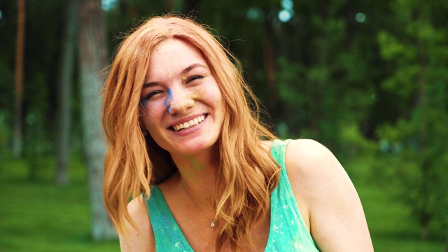 一名红发年轻女子对着满是胡里粉的相机大笑的肖像视频素材