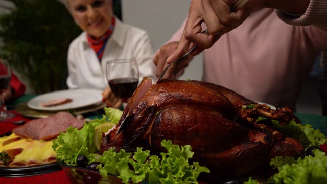 男人在感恩节晚餐切火鸡的特写镜头视频下载