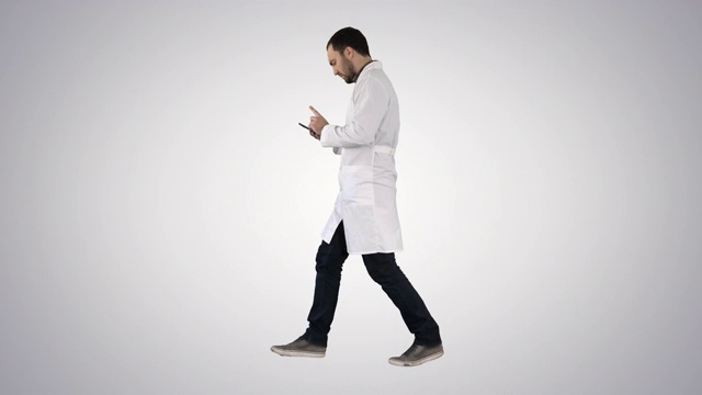 行走医疗专业人员使用智能手机，并在梯度背景上做注意手势视频素材