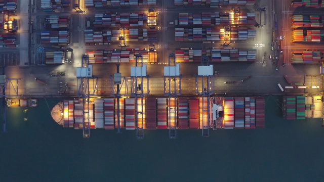 集装箱船夜间作业，远洋集装箱船经营国际进出口物流运输，鸟瞰图。视频素材