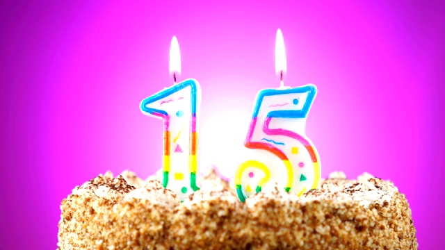 生日蛋糕和燃烧的生日蜡烛。数量15。背景的颜色变化视频下载