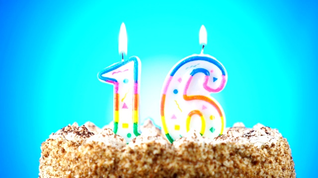生日蛋糕和燃烧的生日蜡烛。16号。背景的颜色变化视频下载