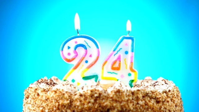 生日蛋糕和燃烧的生日蜡烛。24。背景的颜色变化视频下载