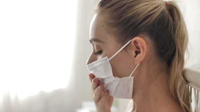 生病的妇女在家里用口罩保护咳嗽视频素材