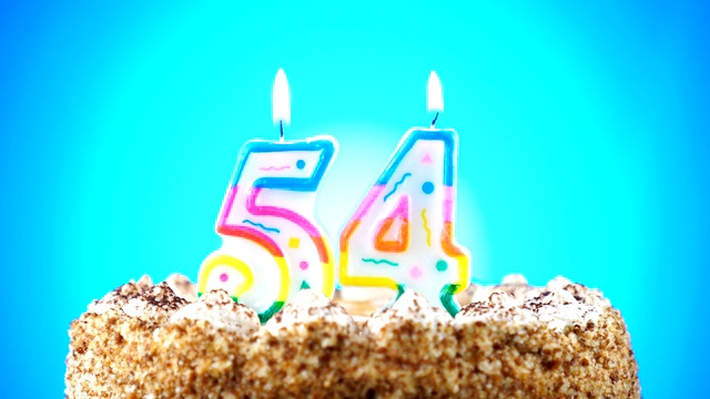 生日蛋糕和燃烧的生日蜡烛。54号。背景的颜色变化视频素材