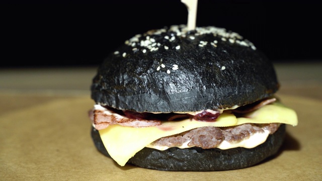 美味的黑汉堡配上肉排，熏肉，芝士和樱桃酱视频下载