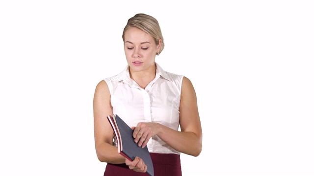 穿正装的女人打开笔记本，在白色背景下看里面视频素材