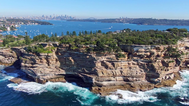 令人惊叹的4k全景无人机飞行的Gap，一个海洋悬崖在南头半岛在沃森湾在悉尼东部郊区。背景是悉尼的中央商务区。视频下载