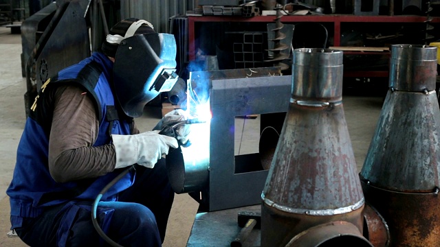 焊工在生产线上焊接金属零件。视频下载