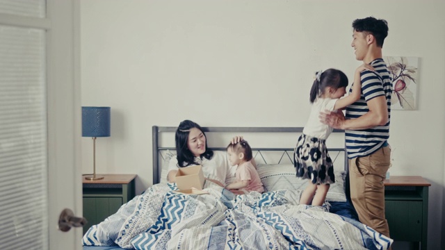 年轻的亚洲女孩在母亲节快乐地在床上跳(慢镜头)视频素材