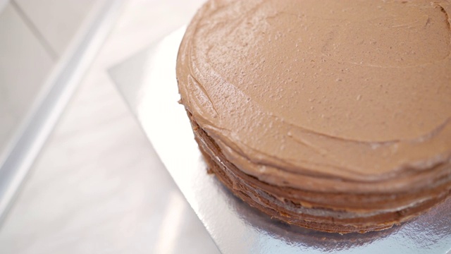 近距离的女人糖霜与巧克力奶油蛋糕视频下载