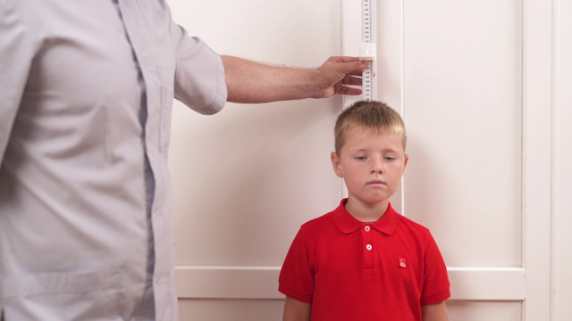 理疗师在测量一个男孩的身高。儿童的概念。体检视频下载