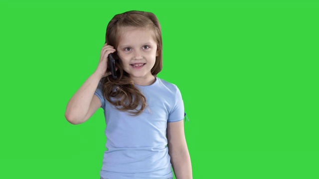 一个小女生在绿色屏幕上用智能手机打电话，Chroma Key视频下载