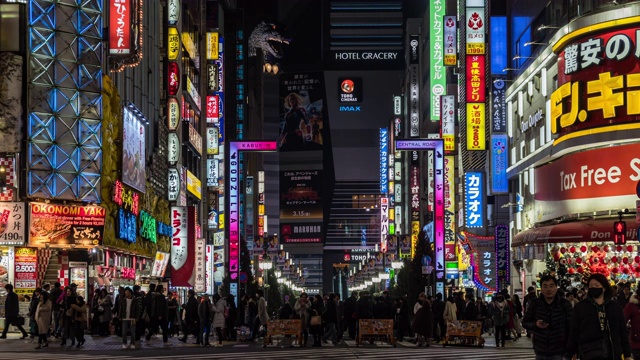 4K时间的推移，新宿在晚上，人群不明的人走在人行道上，汽车在东京，日本。日本霓虹街文化与购物概念视频素材
