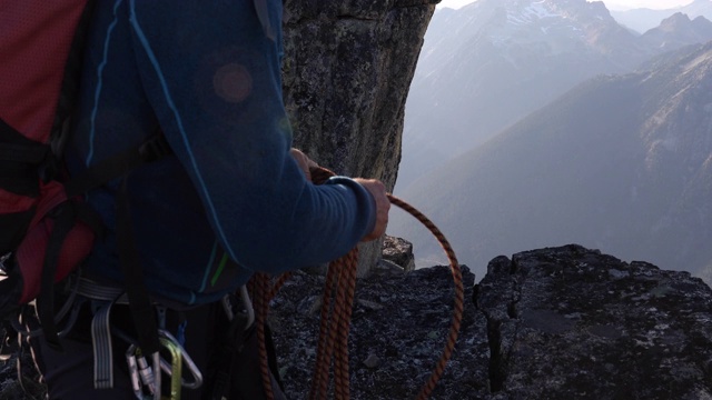 男性登山者在山顶卷绳视频下载