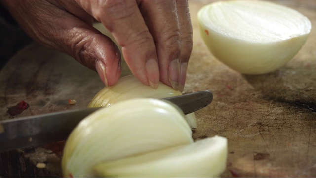 厨师把洋葱切成片。切洋葱。半圈洋葱。厨师的手。切蔬菜是健康的食物。视频素材