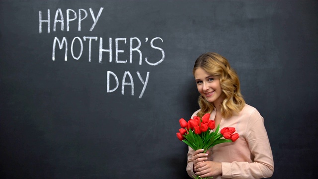 女人拿着鲜花站在签名旁边母亲节快乐，恭喜你视频下载