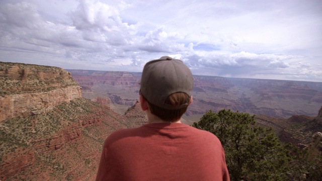 一个十几岁的男孩看着大峡谷国家公园的南缘视频素材