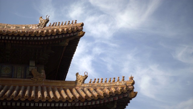 中国北京，蓝天映衬下，紫禁城传统屋顶结构上的动物雕像视频素材