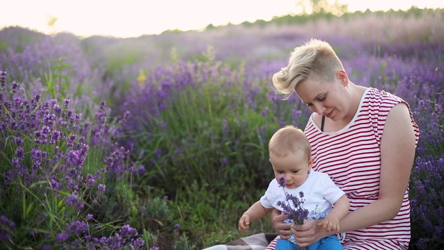 快乐的妈妈带着小儿子在薰衣草地里玩耍视频下载