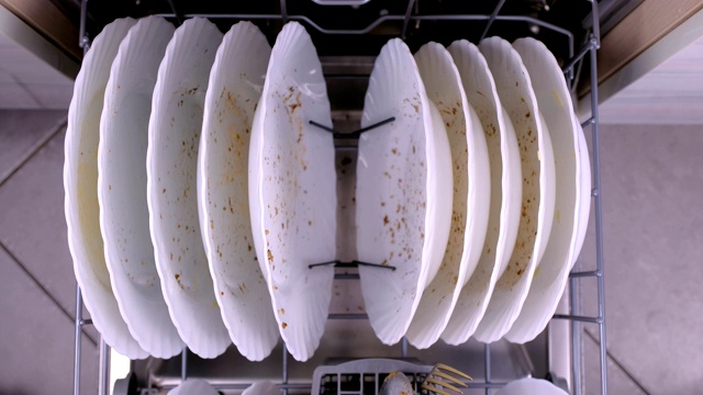 男人的手推着装有脏盘子的洗碗机篮子。视频素材