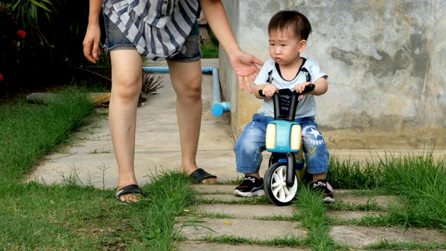 妈妈和她的儿子和孩子一起骑自行车视频素材