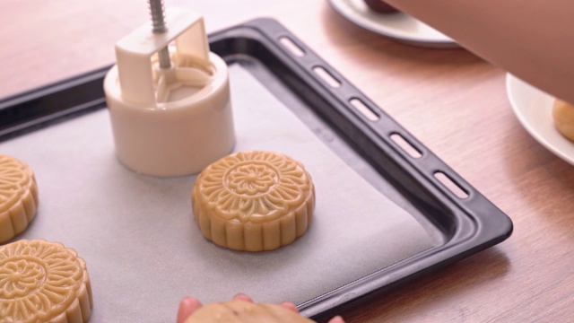 中秋月饼制作工艺——在烤盘上成型月饼糕点的形状。女性节日自制概念。视频下载
