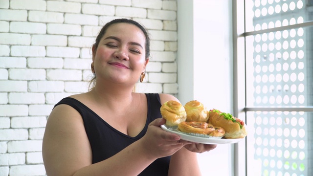 泰国超重妇女很高兴闻到最喜欢的甜面包视频素材