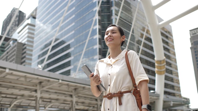 在城市中行走和使用智能手机的亚洲女人视频素材