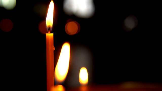 燃烧的蜡烛在黑暗的背景上的特写视频素材
