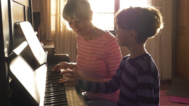老奶奶教孙子弹钢琴视频素材