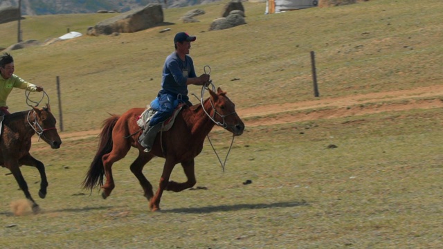 慢动作:在运动比赛中，人们骑马在场地上对着山——乌兰巴托，蒙古视频下载