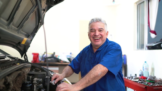 一名高级机械师开着发动机罩修理汽车的肖像视频素材