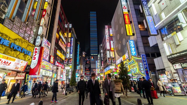 在日本东京的新宿，一群不明身份的人走在街上的4K时间间隔。日本霓虹街文化与购物概念视频素材